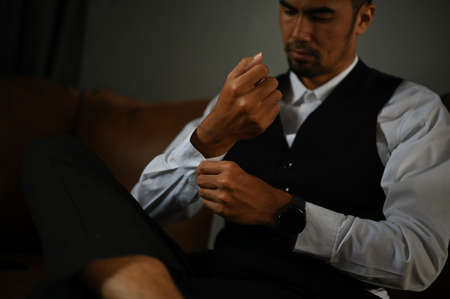 Handsome and professional Asian businessman or male executive manager in formal outfit sits on...