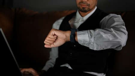 Cropped image, Confident and successful asian businessman checking time on his luxury expensive...