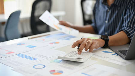 Professional businessman or male financial manager working at his desk, calculating, planning and...