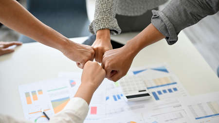 A group of successful businesspeople making fist bump together to cheer up, support and making a...