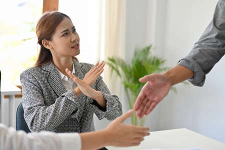 A professional Asian businesswoman disagrees and denies any business dealings with her partners in...