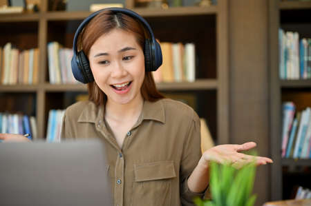Cheerful and friendly young asian female online tutor is tutoring her students on online via laptop...