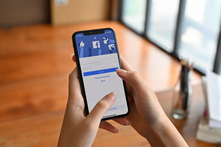 Chiangmai, Thailand - June 29 2022: A female hands holding a smartphone with Facebook login page on...