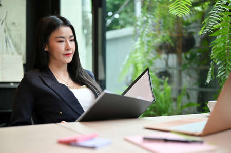 Confident and successful Asian businesswoman or female executive manager in formal suit looking and...