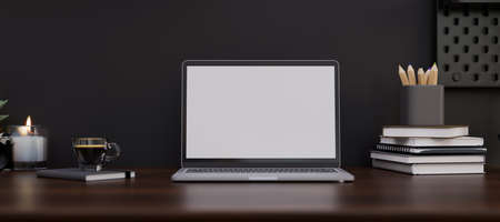 Modern dark stylish workspace with notebook laptop white screen mockup, stationery, book and a cup of coffee on dark wood table over the black wall. 3d rendering, 3d illustrationの写真素材