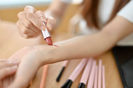 Close-up image, Female beauty blogger swatching her lipstick on her arm. Beauty and fashion conceptの写真素材