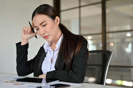 Professional young Asian businesswoman or business worker concentrated working on her task in the office.の写真素材