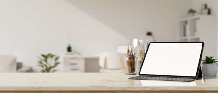 Portable tablet white screen mockup, painting tools and copy space on marble white tabletop over...