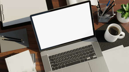 Top view, Notebook laptop white screen mockup, a cup of coffee, stationery and accessories on modern...