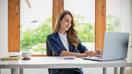 Attractive and successful Asian businesswoman or female executive manager in formal suit is in the...