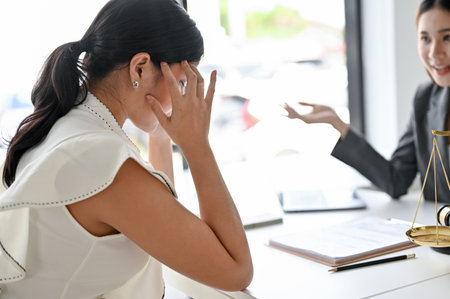 Stressed Asian female client in the meeting with her personal female lawyer or business legal consultant.の写真素材