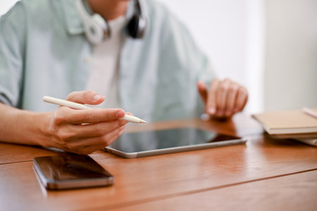 Hipster male freelancer or college student using digital tablet to design his graphic artwork. cropped shotの写真素材