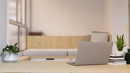 Minimal home workspace with laptop computer, books, decor plants and copy space on wood tabletop over blurred minimal living room in the background. close-up. 3d rendering, 3d illustrationの写真素材