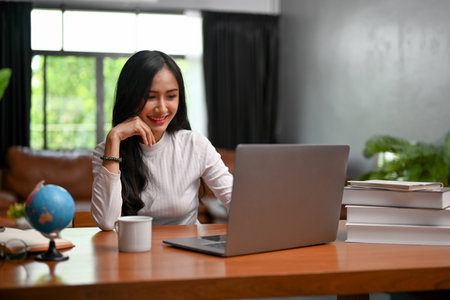 Charming young Asian businesswoman or female business startup entrepreneur working in the office,...