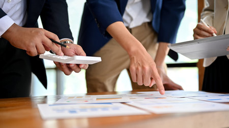 cropped view, Team of professional and talented businesspeople working together, analyzing a business financial data on the report.の写真素材