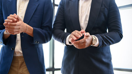Businessmen are applauding their coworkers, congratulating them on their accomplishments during the meeting. cropped imageの写真素材