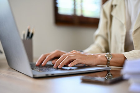 Close-up image, Professional Asian businesswoman or female manager working at her desk, using laptop computer, typing on keyboard.の写真素材