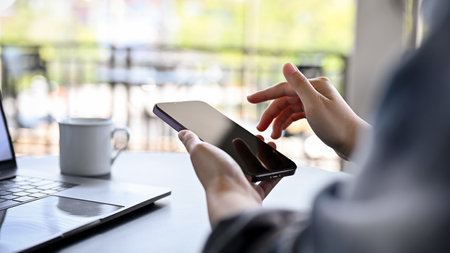 close-up image, A female using her smartphone while relaxing in the coffee shop in the morning.の写真素材