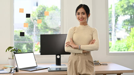 Attractive and beautiful millennial Asian businesswoman or female CEO in casual clothes arms...