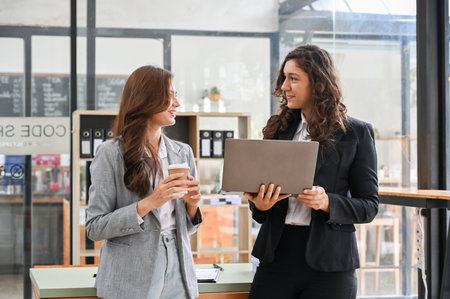 Professional and talented millennial caucasian businesswomen talking, sharing ideas and brainstorming on their business marketing project.の写真素材