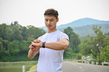 Close-up, Handsome and healthy young Asian man in sportswear checking his heart rate and calories...