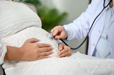 close-up and cropped shot, Female doctor or obstetrician listening baby's heartbeat by her stethoscope. Antenatal care and pregnancy conceptの写真素材