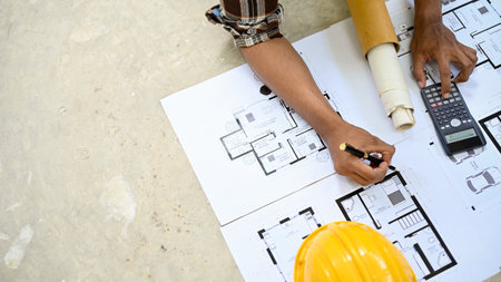 top view, Professional Asian male engineer or architect working and checking on the blueprint....