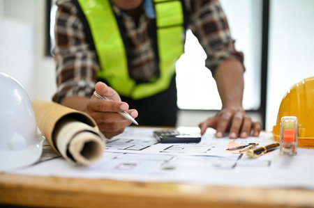 Professional Asian male engineer is working in his office, working and checking the blueprint....