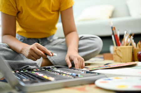 cropped image, A female painter or school student doing some artwork in her living room. painting...