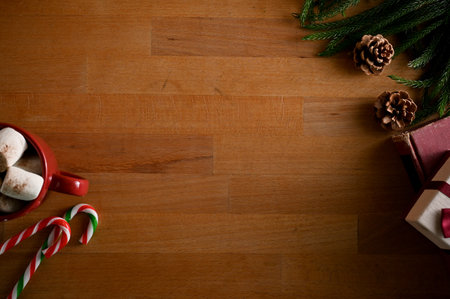 Top view, A copy space for display your text on wooden background with Christmas decorations, candy,...