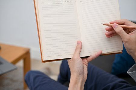 Close-up image, A man's hand holding a blank empty diary book, writing diary or taking notes on a book.の写真素材
