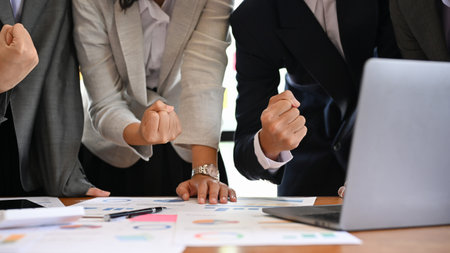 Team of professional and expert businesspeople in the meeting together, making a cheer up hand sign, celebrating the success and victory together. cropped shotの写真素材