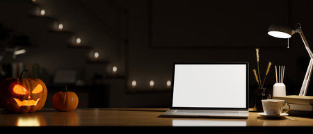 Office desk workspace in the darkness room at night with laptop white screen mockup, coffee cup, table lamp and halloween pumpkins on wood tabletop over dark background. 3d rendering, 3d illustrationの写真素材