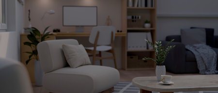 Cozy and minimal living room at night with comfortable sofa, coffee table, computer desk, and home decor. 3d render, 3d illustrationの写真素材