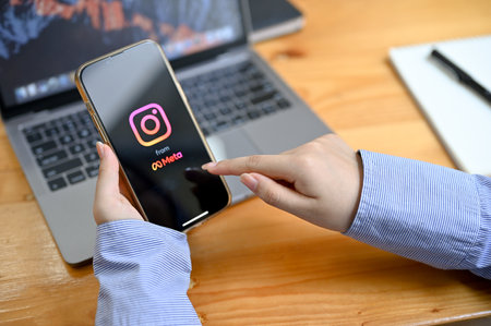 Chiangmai, Thailand - Aug 23 2022: A businesswoman or female hands holding a smartphone with Instagram banner on the screen. Female using Instagram application on her mobile phone. close-up imageのeditorial素材