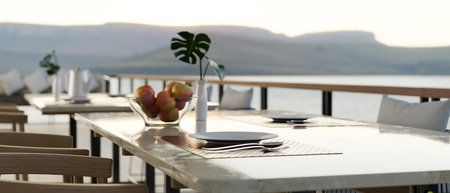 Outdoor restaurant seating space exterior design with luxury dining table setting, comfortable armchairs and beautiful Mountain View. 3d render, 3d illustrationの写真素材