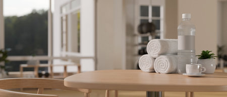 Fitness lounge, towels, a bottle of water, a coffee cup on wood table over blurred background of modern and comfortable fitness gym. 3d render, 3d illustrationの写真素材