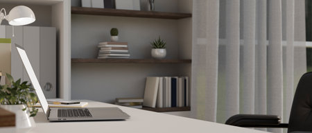 side view, close-up, Modern home working table with laptop computer and decor on table, built-in...