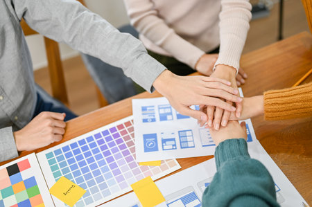 Top view, Team of UX developers and UI designer putting their hands together, meeting and...
