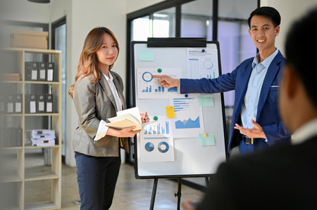 Professional Asian male and female financial analysts presenting financial investment strategy plan...
