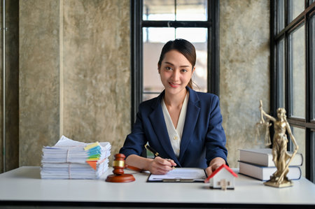 Professional and gorgeous millennial Asian female lawyer or business legal consultant sits at her desk in the office.の写真素材