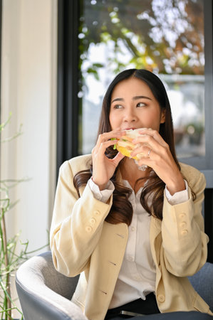 Portrait, Beautiful millennial Asian businesswoman or female office worker sits at the outdoor seat...
