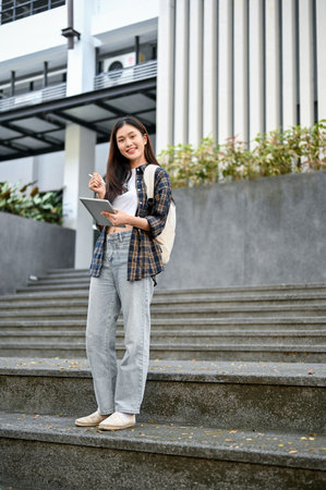 Portrait of a beautiful and pretty young Asian female college student in casual trendy clothes with...