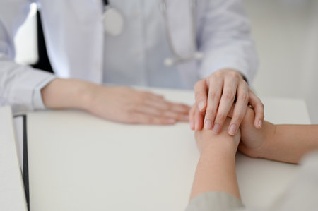 Close-up image of a female doctor holding a patient's hands, supporting and reassuring during the medical checkup. healthcare and medical conceptの写真素材