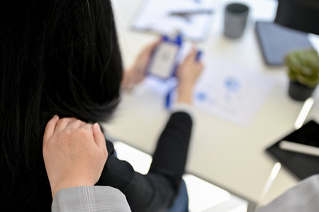 Close-up image of a kind Asian female boss touching on her employee's shoulder, comforting and...