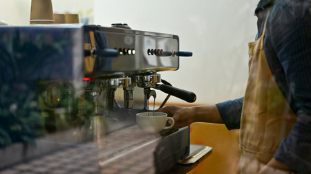 Male barista or bartender in the coffee shop making cappuccino with espresso machine. small business concept. cropped imageの写真素材