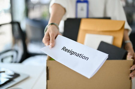 Close-up image of a female office worker handing a resignation letter, being fired from her boss or quitting job by herself.の写真素材