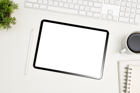 White workspace top view with keyboard, stylus pen, coffee cup, decor and digital tablet white screen mockup.の写真素材
