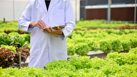 Cropped image of a male biologist or agricultural scientist in uniform holding a clipboard paper,...