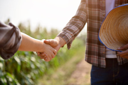 Close up view of farmers checking hands and making a deal with female, reaching agreement deal. Agricultural business conceptの写真素材